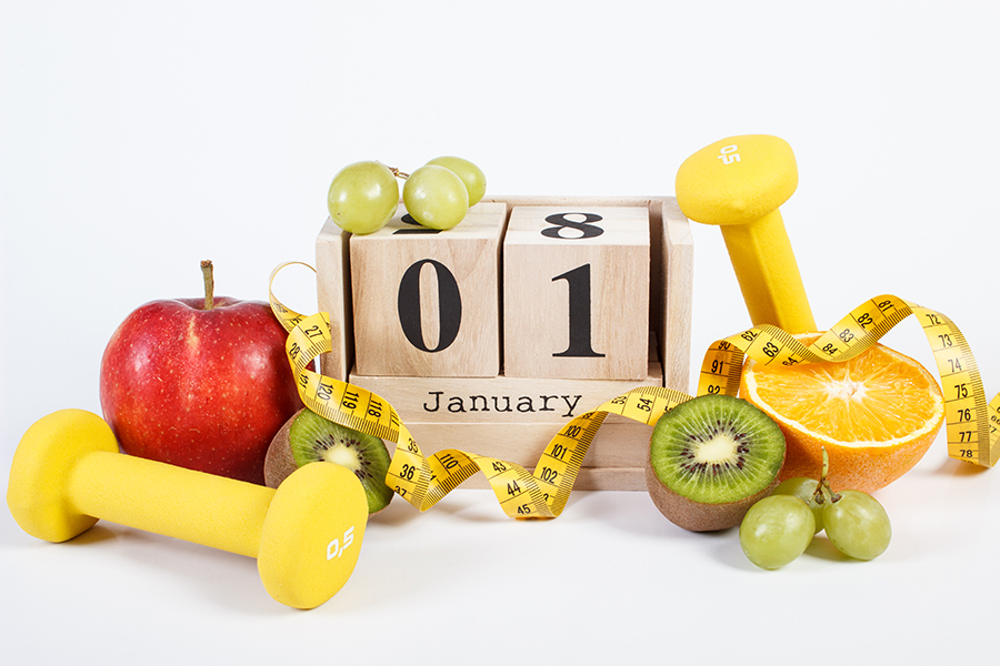 1 Januray on cube calendar, fruits, dumbbells and tape measure, new years resolutions setting health and wellness goals